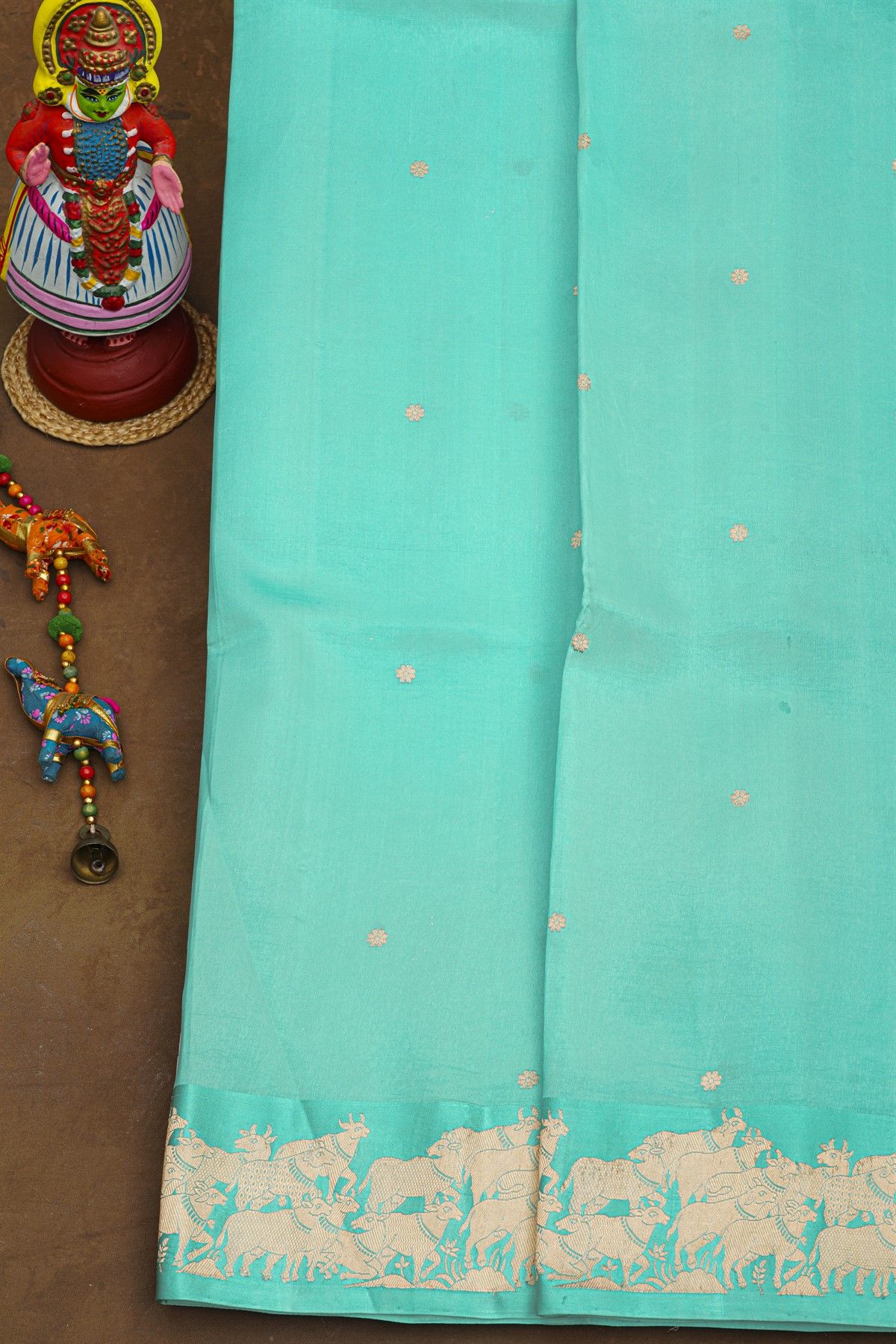 Fancy Matka Silk Sky Blue Saree With Floral Buttis Body And Pichwai Cows Motifs Border