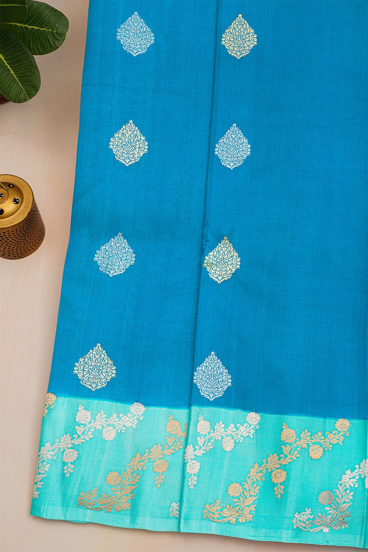 Fancy Matka Silk Peacock Blue Saree With Florals And Buttis Body And Contrast Florals And Leaves Border