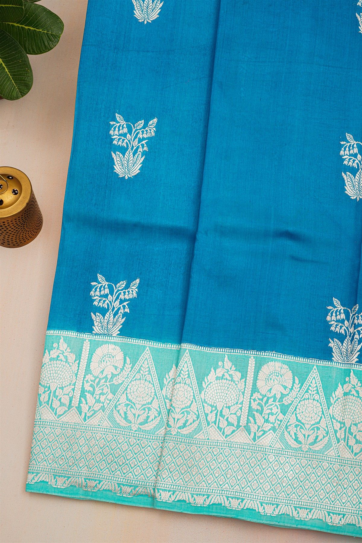 Fancy Matka Silk Peacock Blue Saree With Florals And Buttis Body And Contrast Florals And Leaves Border