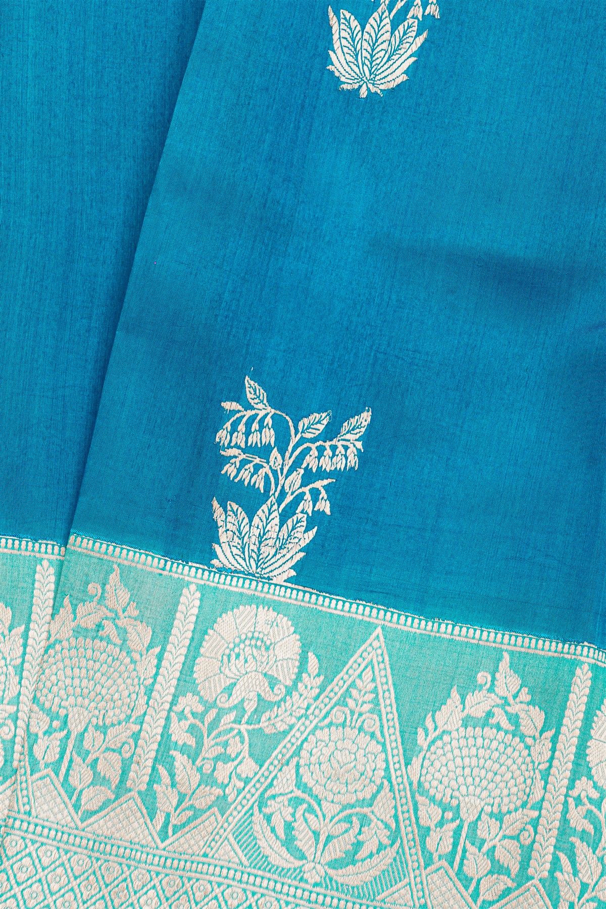 Fancy Matka Silk Peacock Blue Saree With Florals And Buttis Body And Contrast Florals And Leaves Border