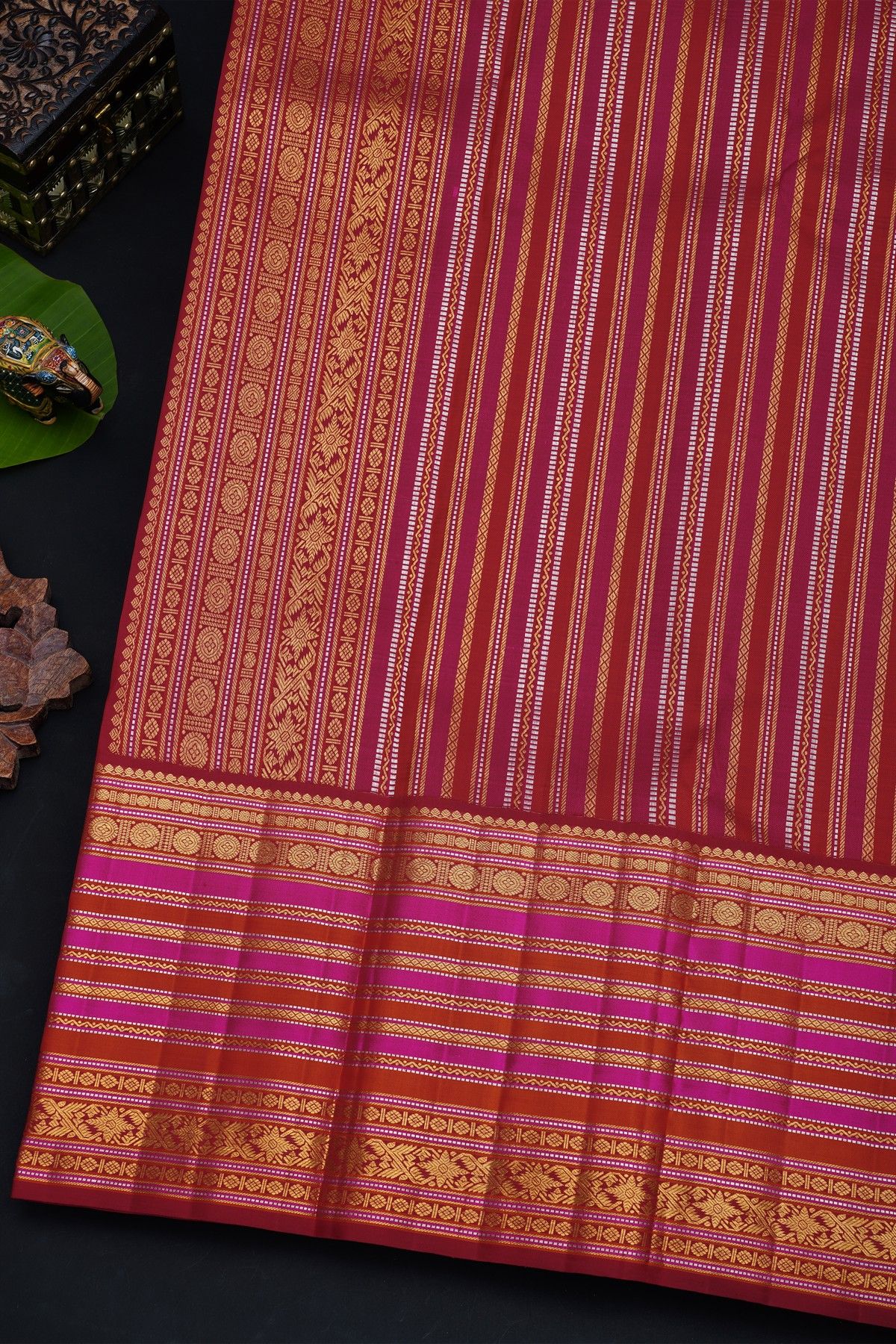 Kancheepuram Silk Maroon Saree With Florals And Peacocks In Checks Body And Self Zig-Zag Lines And Florals Border