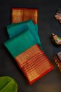 Kancheepuram Silk Peacock Green Saree With Florals And Leaves In Zari Body Red Border